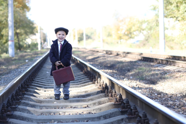 复古照片，一个孩子提着行李箱在枕边行走图片下载