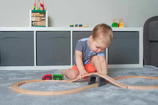 蹒跚学步的男孩在游戏室里玩教育玩具……图片下载