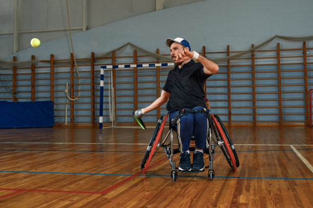坐在轮椅上的年轻人在球场上打网球图片下载