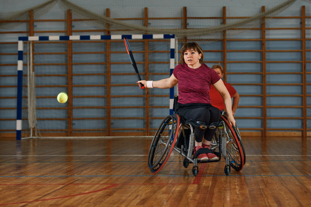 坐轮椅的人在球场上打网球。残疾人轮椅网球图片下载
