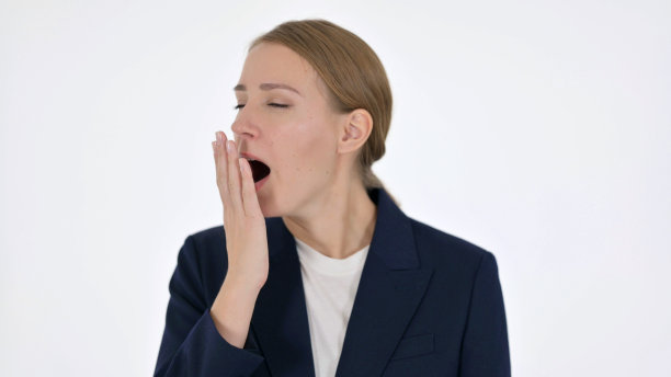 年轻的女商人在白色的背景下打哈欠图片下载