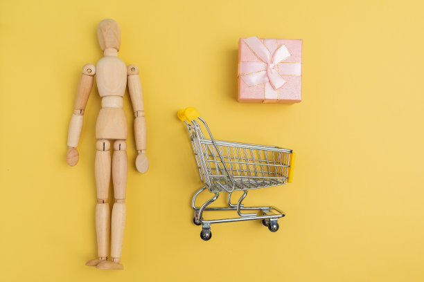 购物车与木制人人体模型购物袋。购买礼品为网上购物，超市概念。本空间图片下载