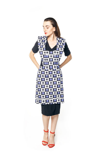 年轻女子身穿黑色连衣裙和红色鞋子，优雅地系着家庭主妇的围裙，背景为白色图片下载