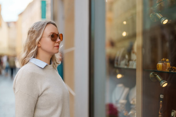 女游客拿着纪念品看橱窗。图片下载