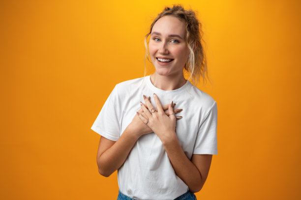 在黄色的背景下笑眯眯的小女孩图片下载