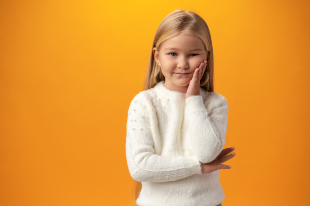 无聊的小女孩在黄色背景下孤独图片下载