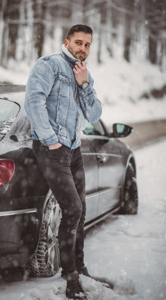 一个英俊的年轻人穿过一片白雪覆盖的森林图片下载