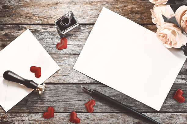 情人节的主题。俯视图的情书，墨水和钢笔，玫瑰和信封在老式木桌子上。空间的文本。图片下载