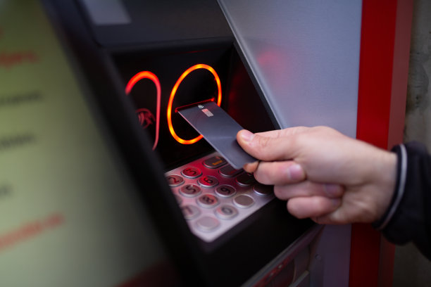 人工从自动取款机上取信用卡。图片下载