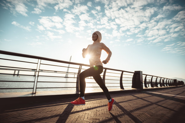 健身女跑步者在海边的桥上跑步图片下载