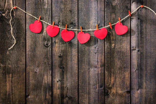 木墙上挂红心绳图片下载