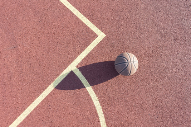 一个篮球放在地板上，打在户外的球场上图片下载