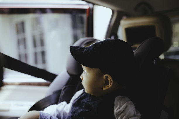 在汽车旅行期间，小男孩坐在婴儿汽车座椅上图片下载