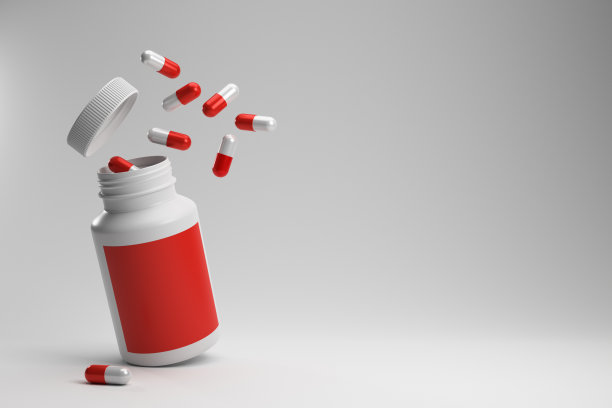 红色和白色胶囊从塑料药瓶白色背景红色标签。图片下载