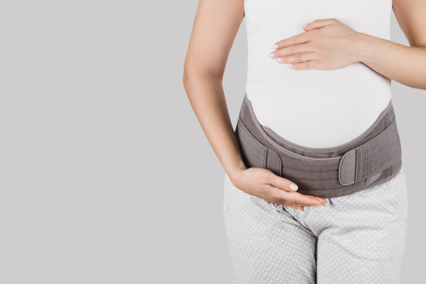 孕妇肚子在产前带孕带孕。骨科腹部支撑腰、背、腹带。怀孕用的腹部支撑或带。水平网络横幅。怀孕模特躯干图片下载