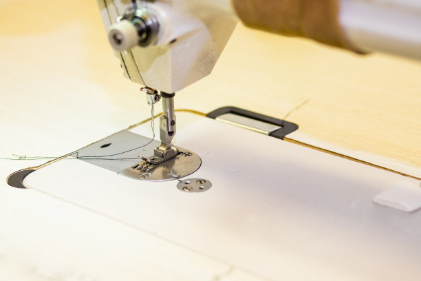 压脚缝纫机。工作场所的缝纫机。服装行业，设计师工作室，裁缝加工。有选择性的重点。副本的空间。裁缝车间。技术、材料、设备概念。图片下载