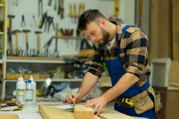 年轻的白人木匠用角尺在甲板上画画图片下载