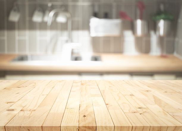 有选择性的重点。木桌顶部模糊厨房柜台背景。图片下载
