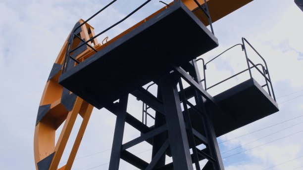 绿色草地上的现代油画摇椅。一桶石油的成本概念，石油生产和加工的原材料图片下载