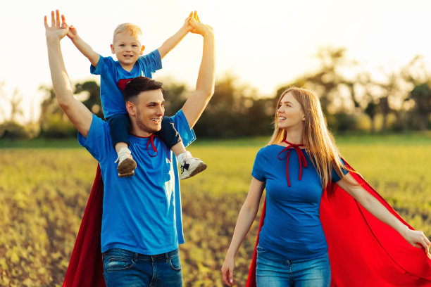欧洲超级家庭概念，户外，慈爱的父亲抱着脖子，超级英雄家庭在日落时分奔跑在大自然中图片下载