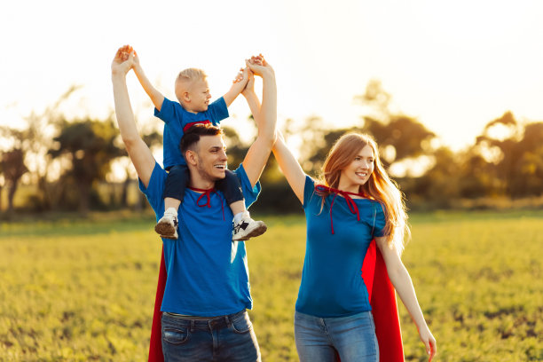 欧洲超级家庭概念，户外，慈爱的父亲抱着脖子，超级英雄家庭在日落时分奔跑在大自然中图片下载