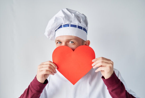 情人节概念:男厨师穿制服配红心图片下载