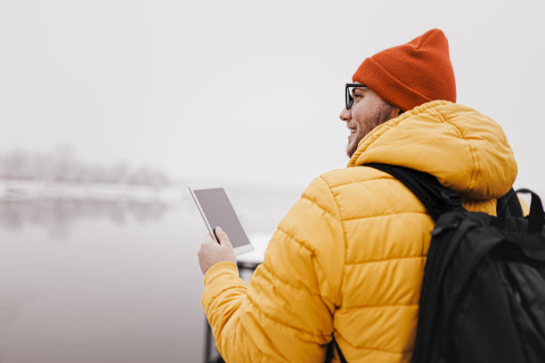 男子使用数码平板电脑和行走在雪天的自然图片下载