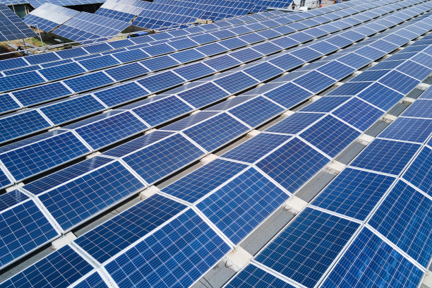 太阳能发电厂鸟瞰图，蓝色光伏板安装在工业建筑屋顶上，产生绿色生态电力。生产可持续能源的理念。图片下载