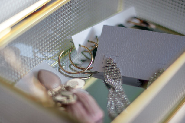 金色的耳环。女性的珠宝。古董装饰背景。漂亮的银和金手镯，项链和耳环在玻璃箱子里。从上面俯视图片下载