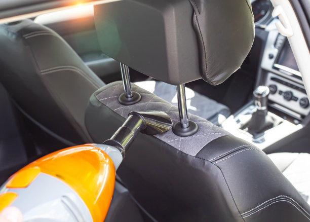 现代汽车吸尘器清洁汽车内部的灰尘和污垢，特写。背景图片下载