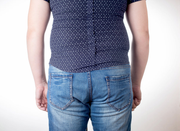 白色背景上穿着黑色紧身衣的男人。超重，不健康的饮食和减肥概念，特写。尺码很小的衣服图片下载