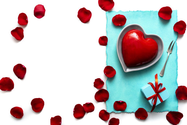 情人节红心形蛋糕上有红玫瑰花心形和白色花瓣图片下载