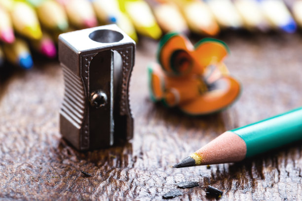 金属卷笔刀的微距照片，在质朴的木桌下，有文字空间图片下载