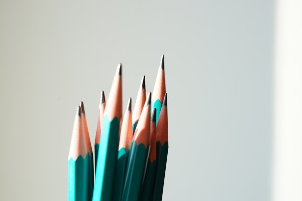 绿色的石墨铅笔在阳光下白色的墙壁背景图片下载