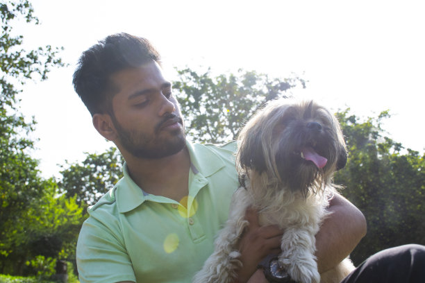 一个年轻人在公园里玩狗图片下载