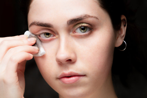 美丽的女孩卸妆。黑色背景。近距离图片下载