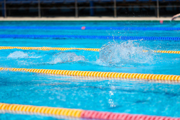 游泳池里水溅起水花。暑假假期。图片下载