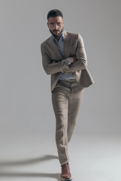 性感的年轻商人与眼镜交叉手臂和走路图片下载