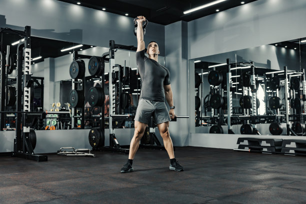 一名强壮的男子在健身房用一只手臂举重。功能性锻炼和健康的生活理念。图片下载