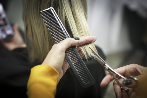 理发师的手握剪刀和梳子和剪头发的特写图片下载