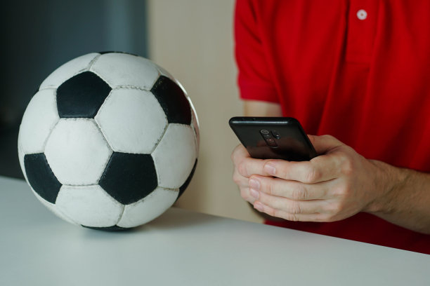 年轻人用智能手机在网上赌球的特写。图片下载