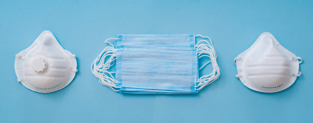 白色品种口罩呼吸器在蓝色的背景。口罩可以防止环境污染、流感病毒和冠状病毒。图片下载