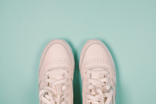 新的白色运动运动鞋鞋在蓝色紫色的背景。平躺，俯视图。横幅图片下载