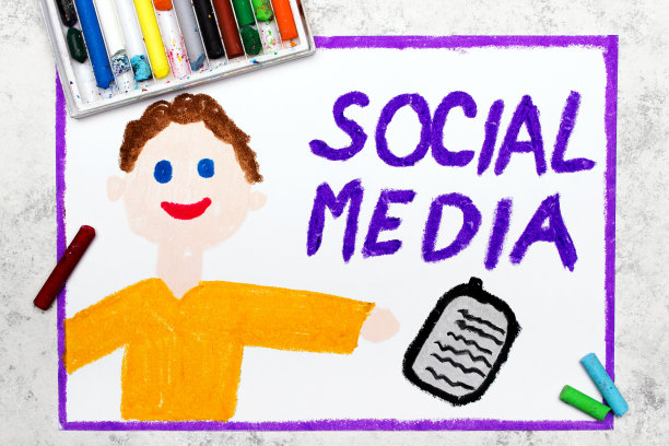 彩图:微笑的男孩拿着手机和文字社交媒体图片下载