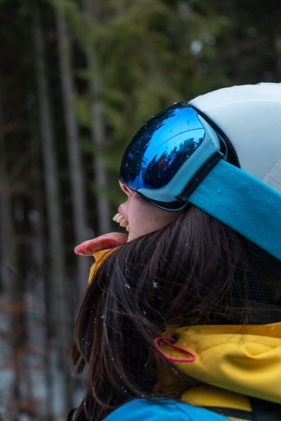 女滑雪者伸出舌头抓雪图片下载