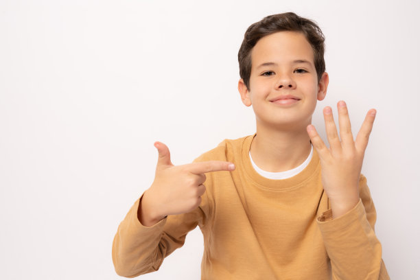 小男孩穿着休闲的衣服，指着四号手指，微笑着自信和快乐。图片下载