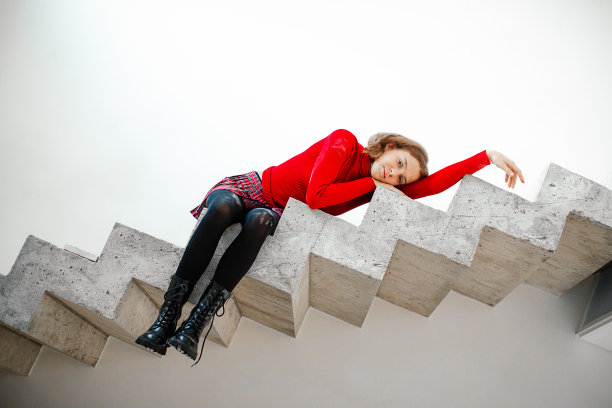 青少年过渡期的孤独感、学习困难。一个女生斜倚在水泥楼梯的台阶边，脚下空无一物。图片下载