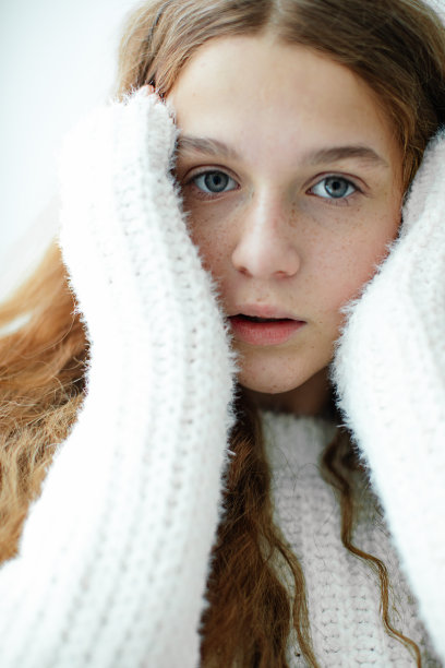 十几岁的女孩有着蓬松的红色头发和迷人的雀斑，严肃地看着镜头。特写镜头。内心世界。蓬松的头发。自然美景。不同的人。温柔和脆弱。图片下载