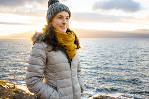 日落时戴着黄色围巾的女人的肖像图片下载