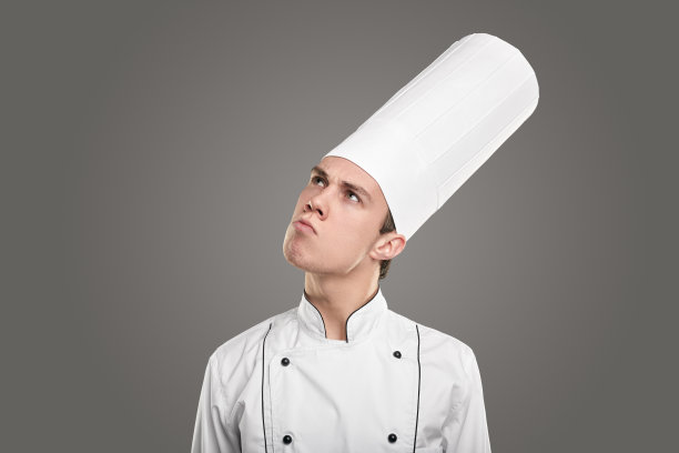 穿着白色制服的厨师沉思着向上看图片下载